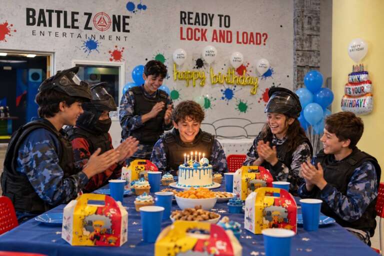 Birthday party at Battle Zone with kids in tactical vests around a cake