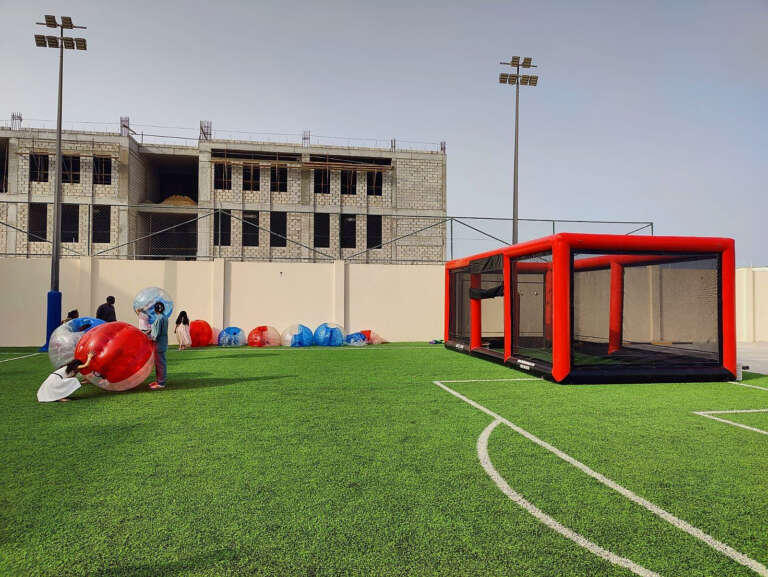 Outdoor event setup with bubble football and target cage