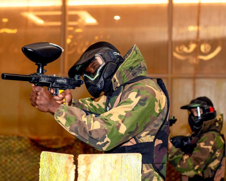 Player aiming from cover with a teammate behind