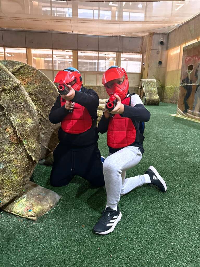 Birthday kids in red masks aiming