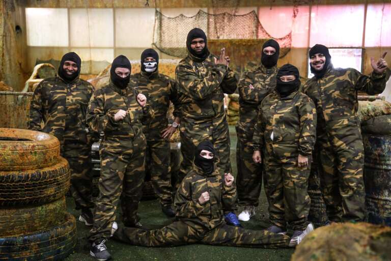 Corporate team in camo suits and balaclavas