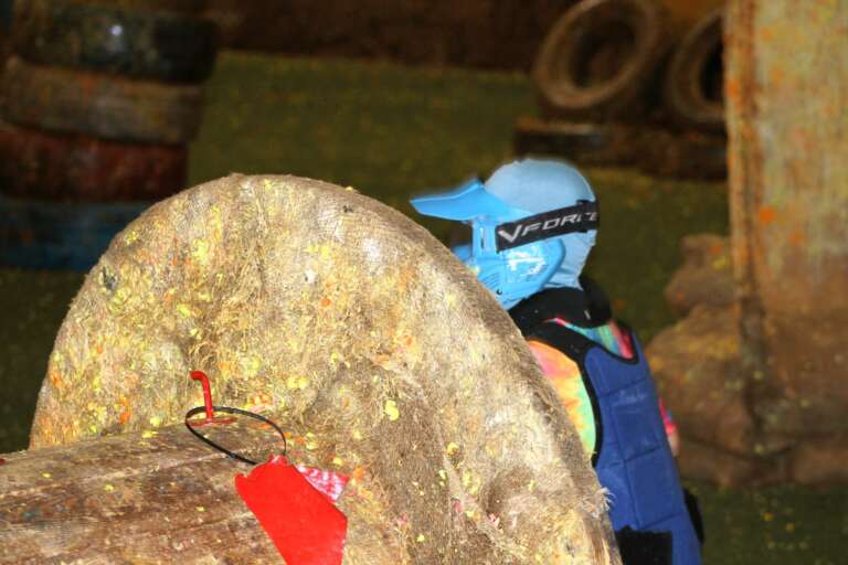 Junior in a blue mask peeking from cover