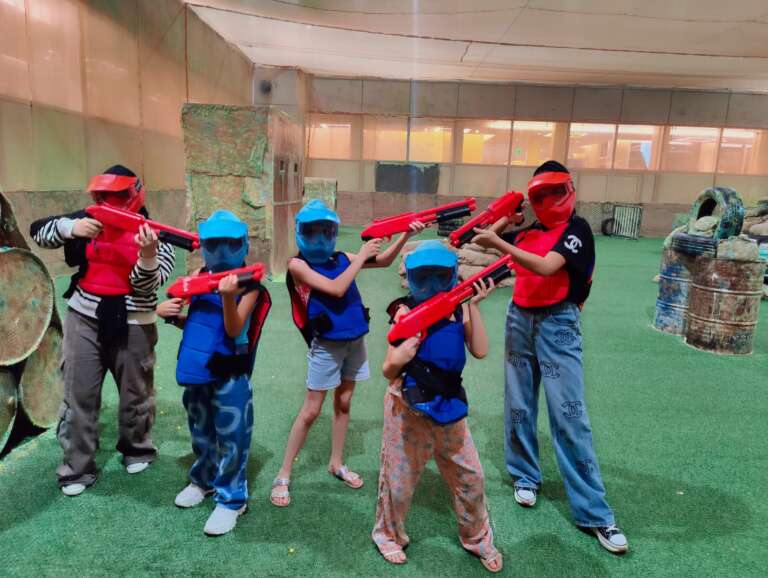 Students aiming in a line with kids markers