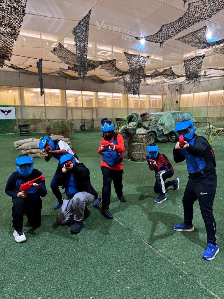 Students in blue masks posing as a team