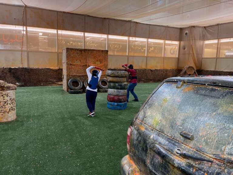 Students playing on the field by the car