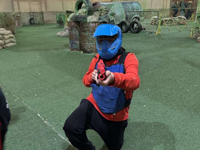 Masked junior player aiming a kids’ marker